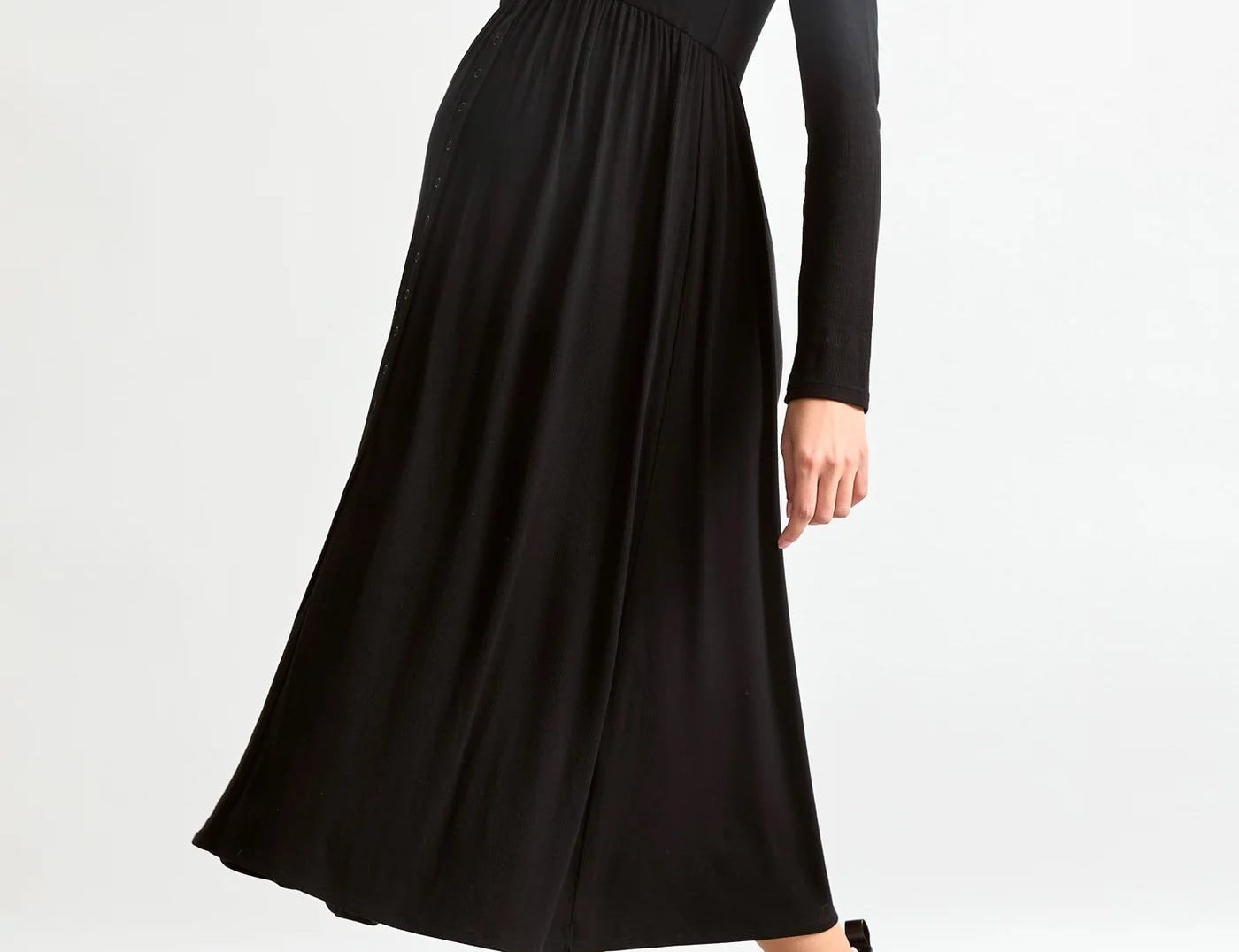 Woman wearing a black dress and black boots on a white background