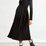 Woman wearing a black dress and black boots on a white background