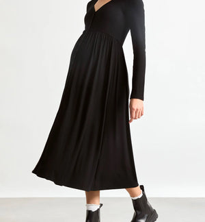Woman wearing a black dress and black boots on a white background