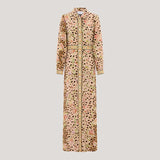 A long-sleeved maxi shirt dress with a mixed print of leopard spots, pink roses, and green leaves on a beige base, featuring a gold patterned trim down the front and cuffs.