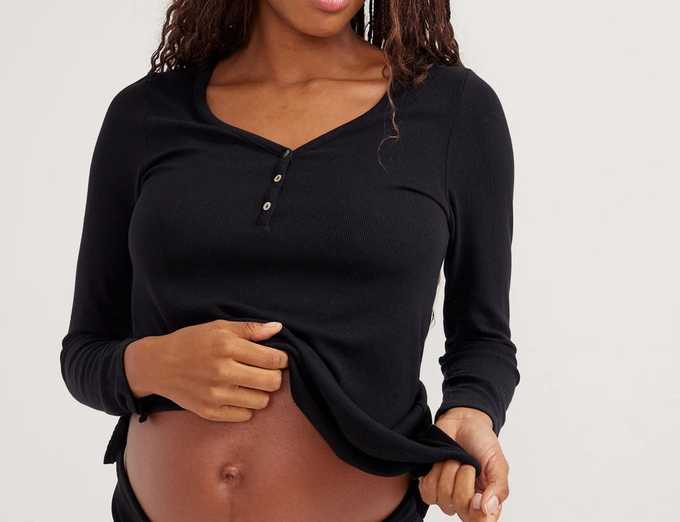 Woman wearing a black long-sleeve top against a white background
