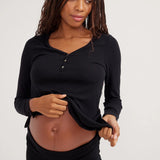 Woman wearing a black long-sleeve top against a white background