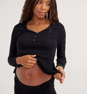 Woman wearing a black long-sleeve top against a white background