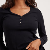 Black long-sleeve top worn by a person on a white background