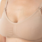 Beige bra being worn on a plain background