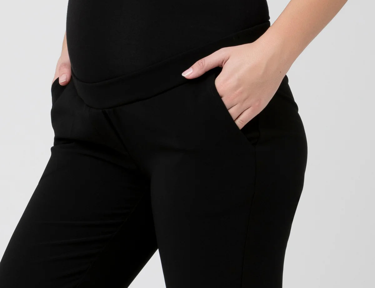 Black pants worn by a person on a white background
