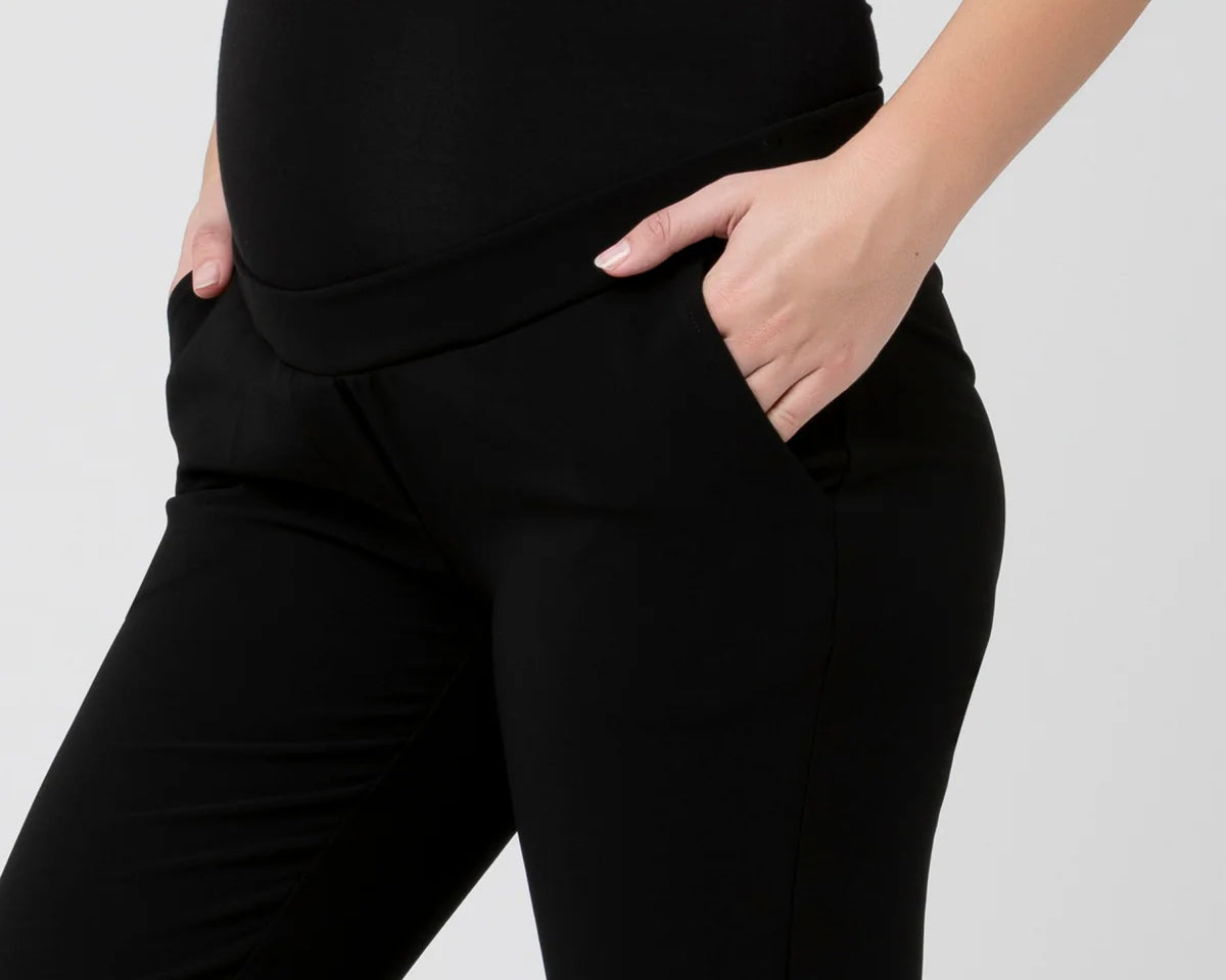 Black pants worn by a person on a white background
