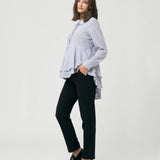 Woman wearing a striped shirt and black pants on a white background