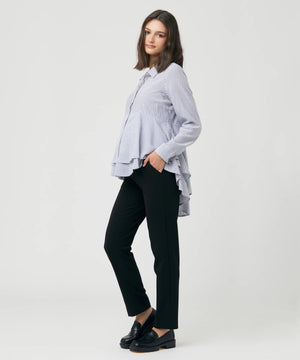 Woman wearing a striped shirt and black pants on a white background