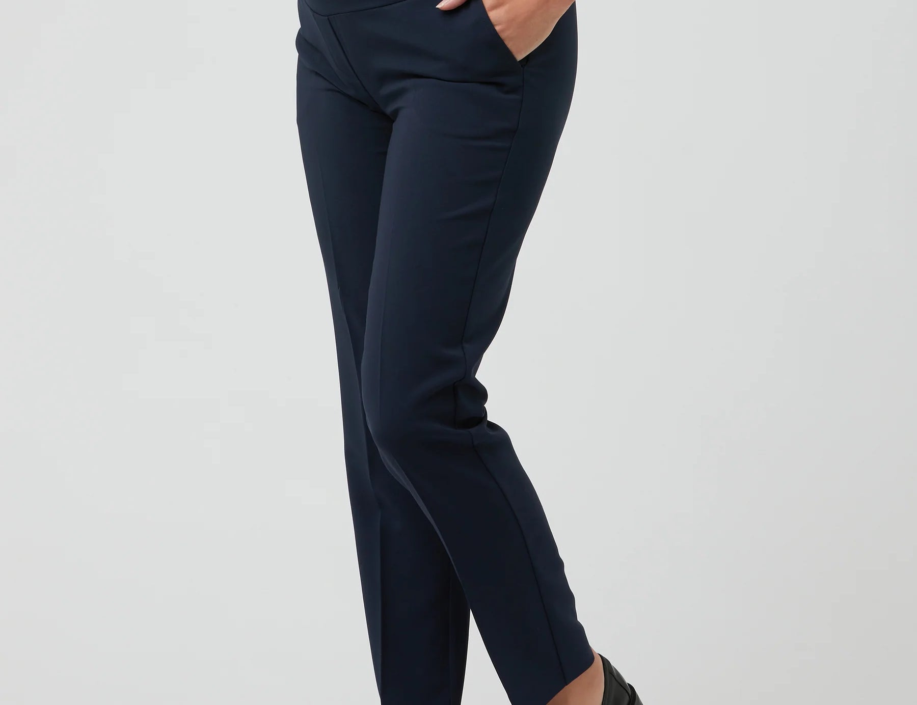 Navy blue maternity pants worn by a person on a light gray background