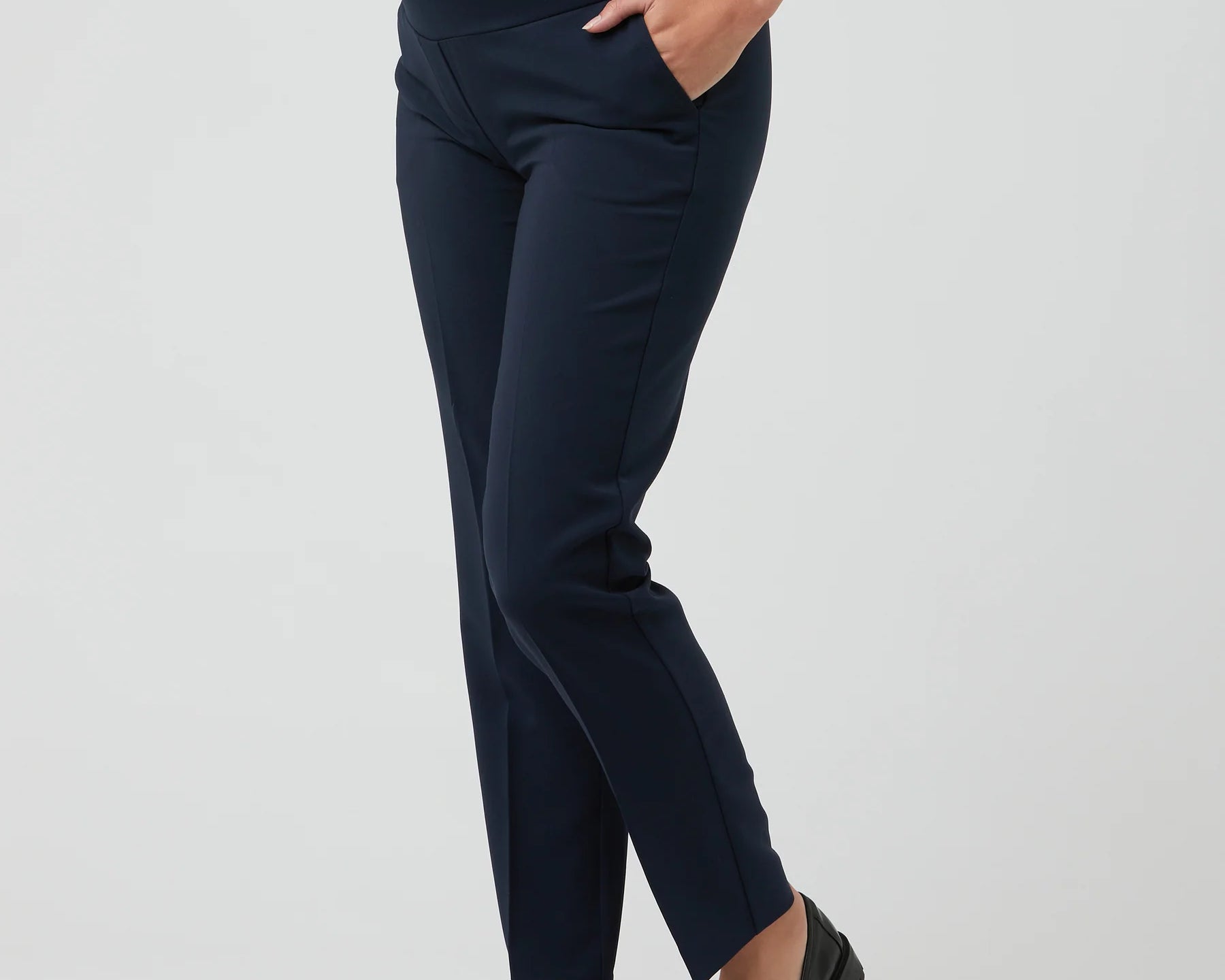 Navy blue maternity pants worn by a person on a light gray background
