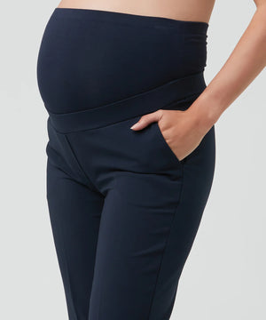 Navy blue maternity pants worn by a person on a light gray background