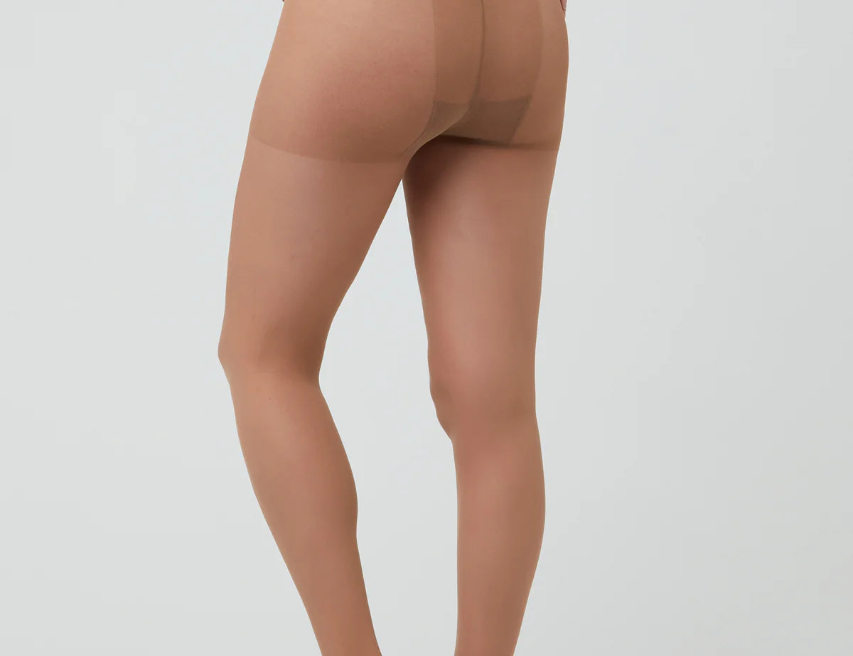 Beige sheer stockings worn by a model on a white background