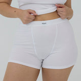 A close-up of a model wearing white ribbed high-waisted briefs with a visible waistband label reading 'RENUE'.