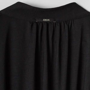 Black garment with 'AWAN' label on a light gray background