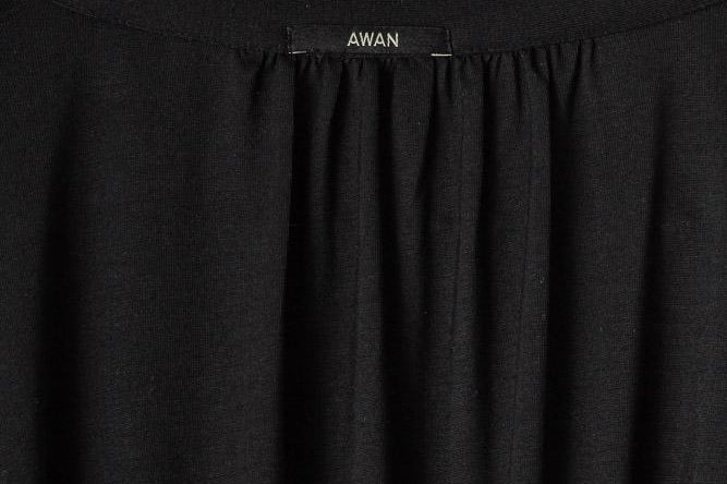 Black garment with 'AWAN' label on a light gray background