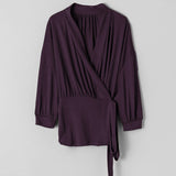 Purple wrap-style top on a light gray background