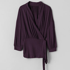 Purple wrap-style top on a light gray background