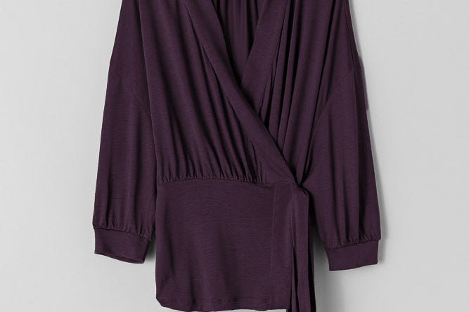 Purple wrap-style top on a light gray background
