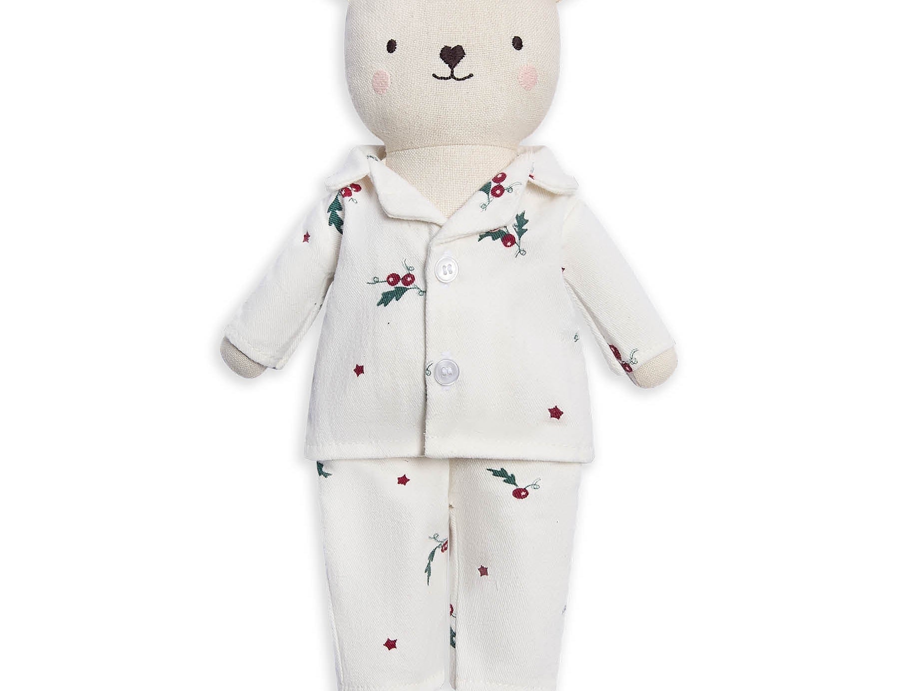 A plush teddy bear wearing a cream-colored pajama set with a small red berry and green holly print, set against a plain white background.