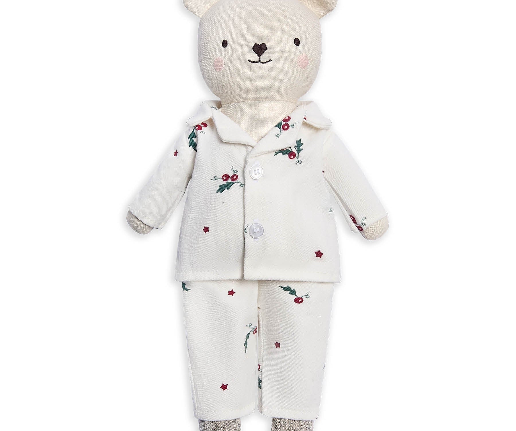 A plush teddy bear wearing a cream-colored pajama set with a small red berry and green holly print, set against a plain white background.