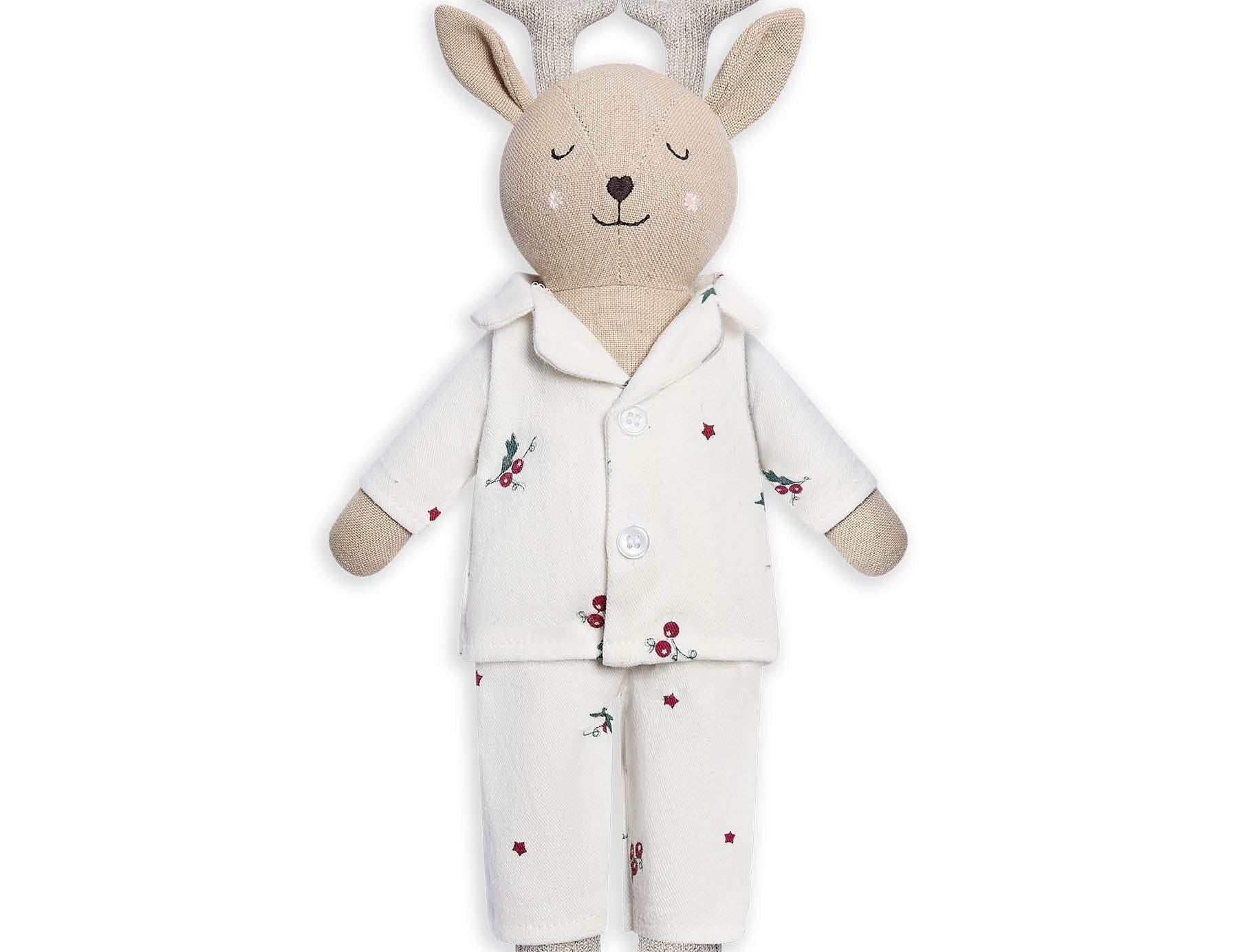 A plush stuffed deer toy wearing a cream pajama set with small red berry and green leaf prints, on a plain white background.