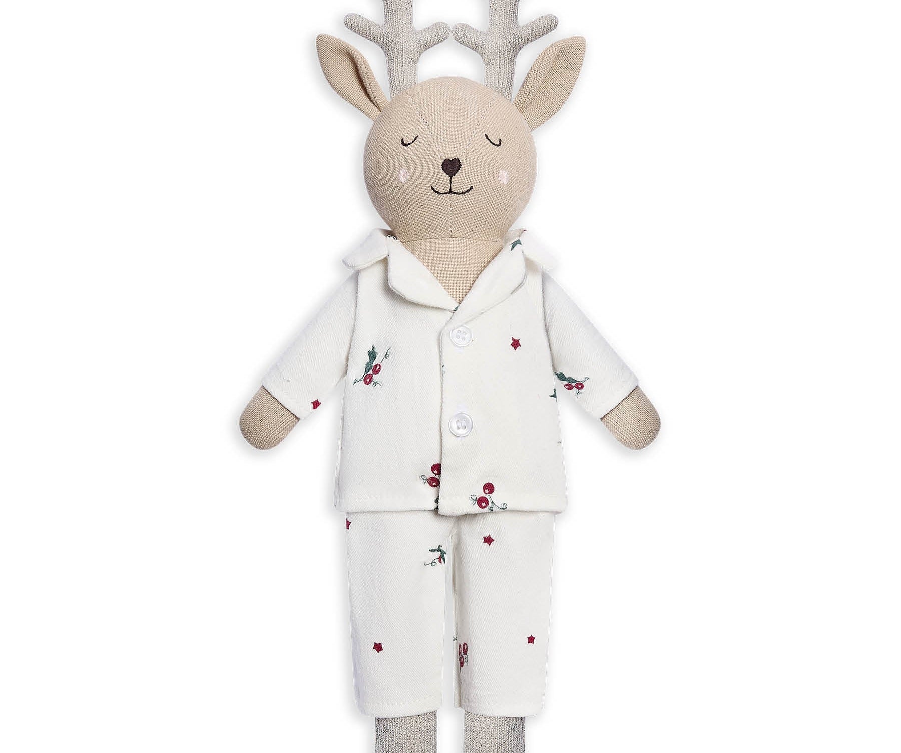 A plush stuffed deer toy wearing a cream pajama set with small red berry and green leaf prints, on a plain white background.