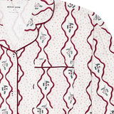 A close-up of a pajama shirt by Avery Row, featuring a white base with light pink polka dots, dark red wavy vertical lines, and small green and pink floral motifs.