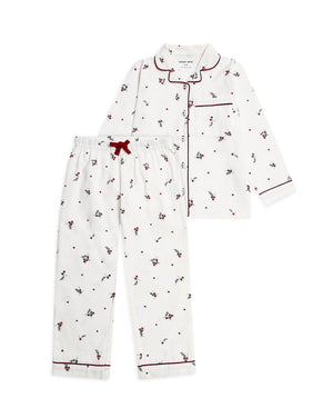 A two-piece children's pajama set featuring a white long-sleeve button-front top and matching pants, both printed with small red cherries and dots, finished with red piping and a red drawstring.