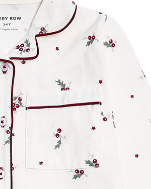 White long-sleeve pajama top with dark red piping, featuring a chest pocket and an all-over holly and berry print with small star accents.