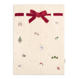 Beige fabric with Christmas-themed patterns and a red velvet bow on a white background