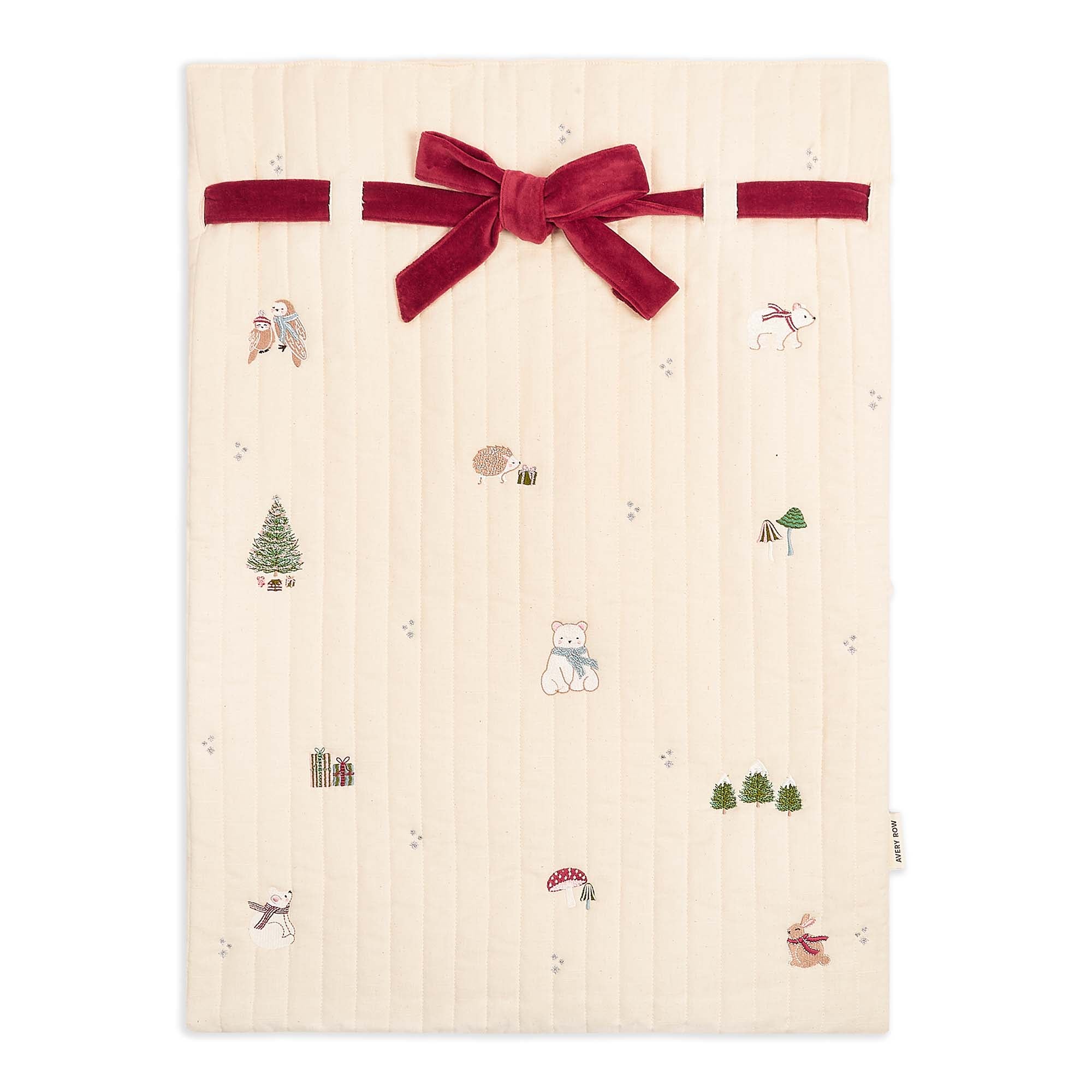 Beige fabric with Christmas-themed patterns and a red velvet bow on a white background