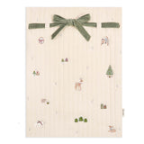 Beige fabric with nature-themed embroidery and a green velvet ribbon on a white background