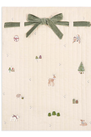 Beige fabric with nature-themed embroidery and a green velvet ribbon on a white background