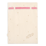 A cream-colored quilted baby blanket with pink elastic bands at the top and small gold embroidered stars, featuring the text 'social learning from the best pet' in gold script near the bottom right.