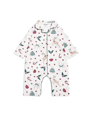 A baby long-sleeve footless romper pajama with a festive Christmas print featuring deer, candy canes, holly, and pine trees on a white background, with green piping trim.