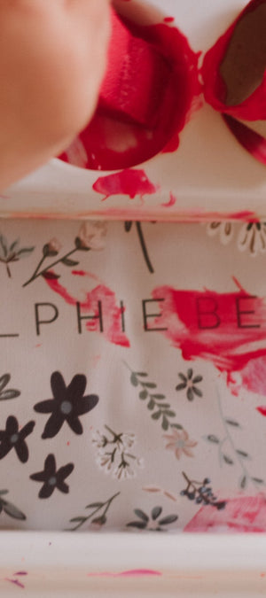 Hand interacting with a floral-patterned product box labeled 'Ralphie Bear'.