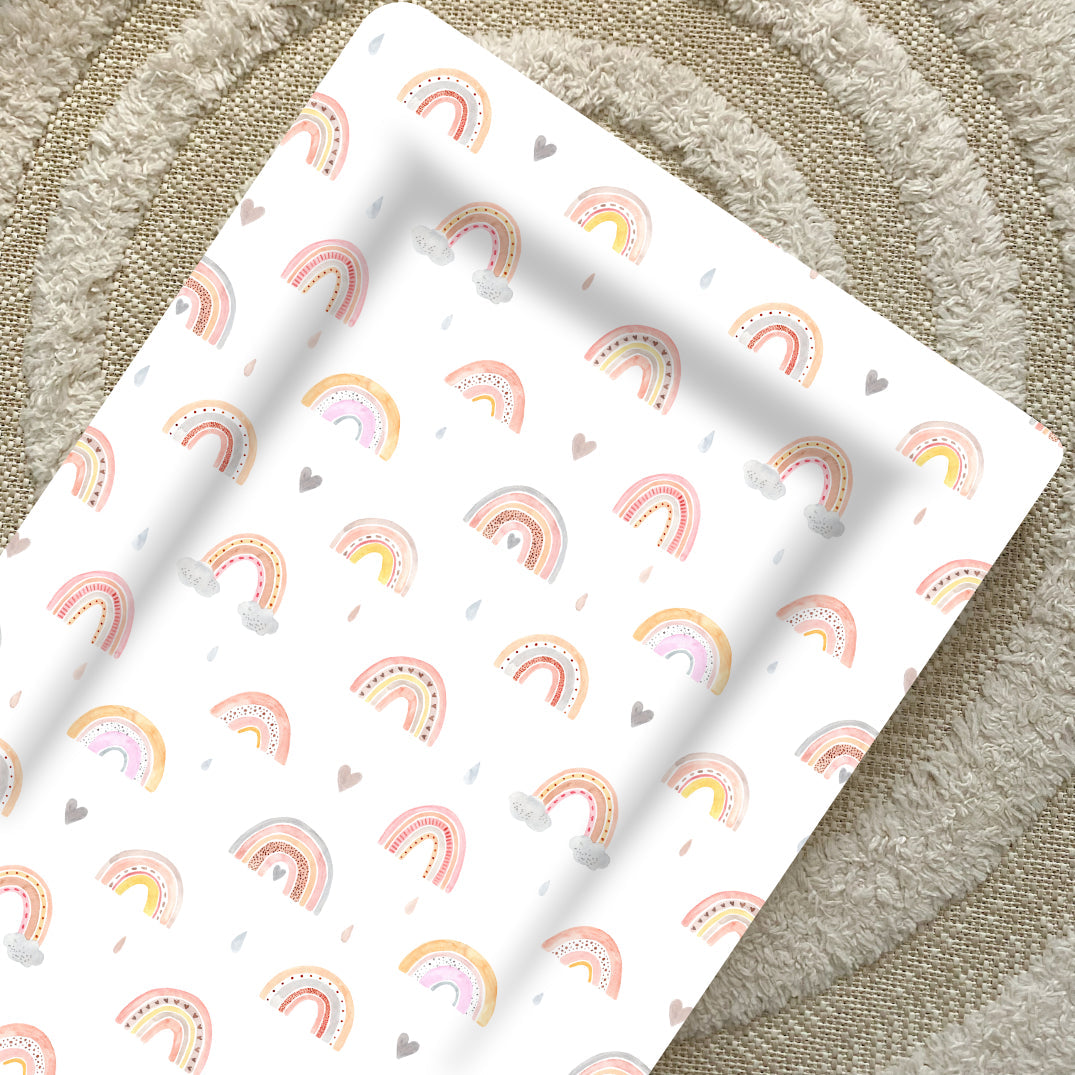 Standard Changing Mat Beau Rainbow Print seen from above on a cream textured rug, showing the raised edges