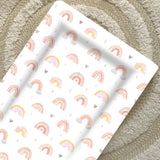 Standard Changing Mat Beau Rainbow Print seen from above on a cream textured rug, showing the raised edges