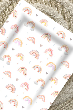 Standard Changing Mat Beau Rainbow Print seen from above on a cream textured rug, showing the raised edges