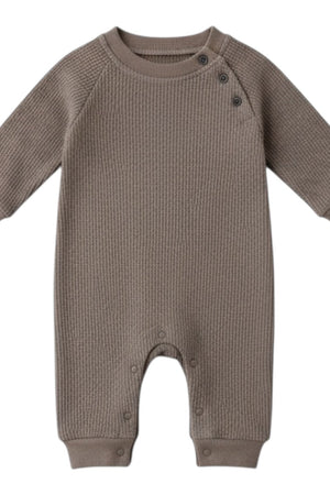 Waffle Long-Sleeve Baby All in One in brown laid flat, showing shoulder buttons, ribbed cuffs and leg poppers