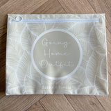 Hospital bag organiser pouches, beige leaf, flat pouch labelled Going Home Outfit on a wooden floor