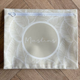Hospital bag organiser pouches, beige leaf, flat pouch labelled Muslins on a wooden floor