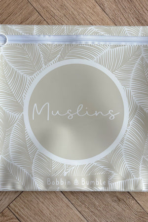 Hospital bag organiser pouches, beige leaf, flat pouch labelled Muslins on a wooden floor