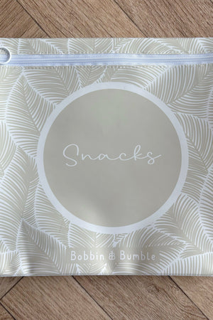 Hospital bag organiser pouches, beige leaf, flat pouch labelled Snacks on a wooden floor