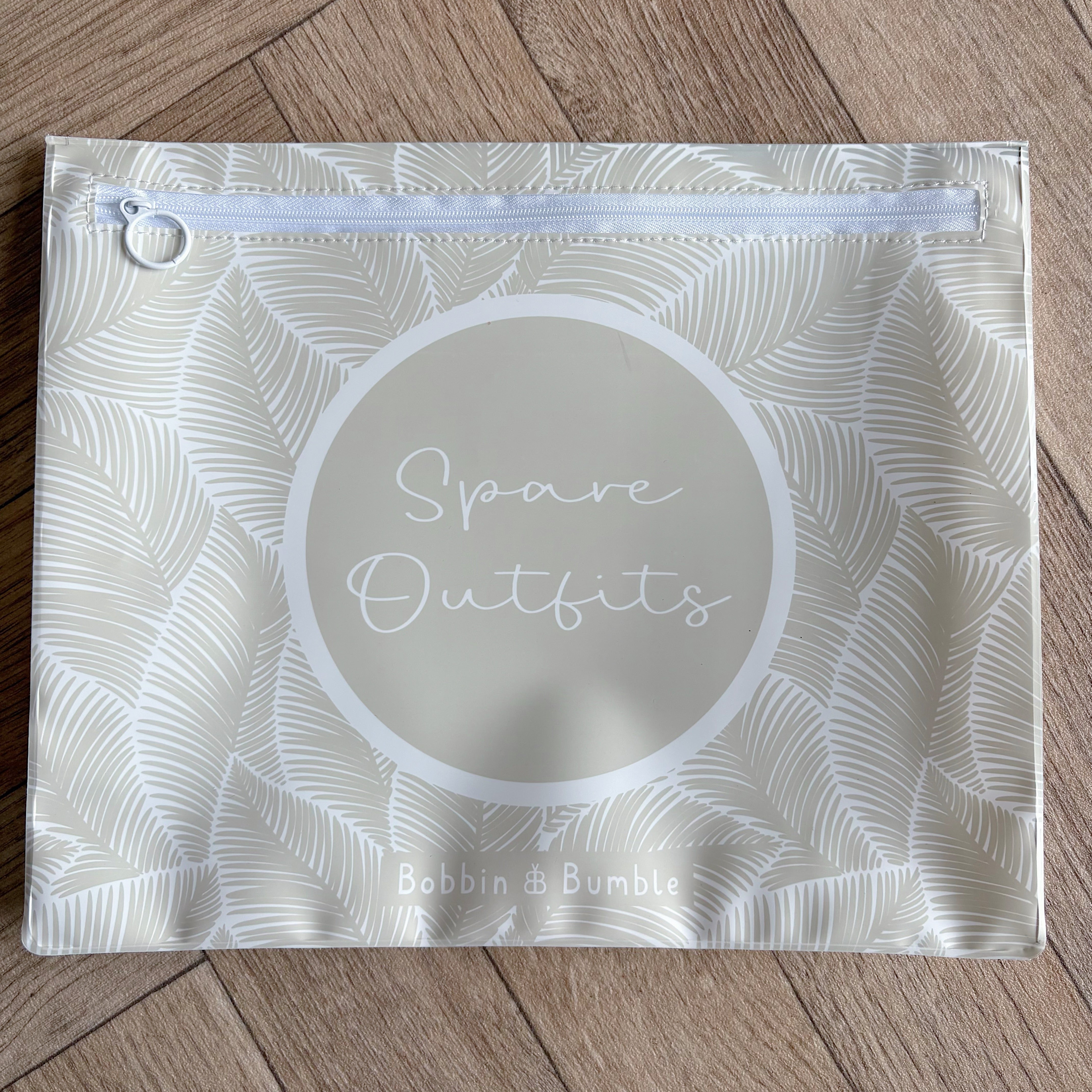 Hospital bag organiser pouches, beige leaf, flat pouch labelled Spare Outfits on a wooden floor