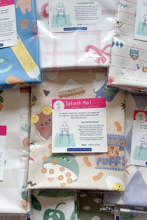 Stack of packaged splash mats in different prints, including Pot Plants, pink bow, circus animals and cereal snacks