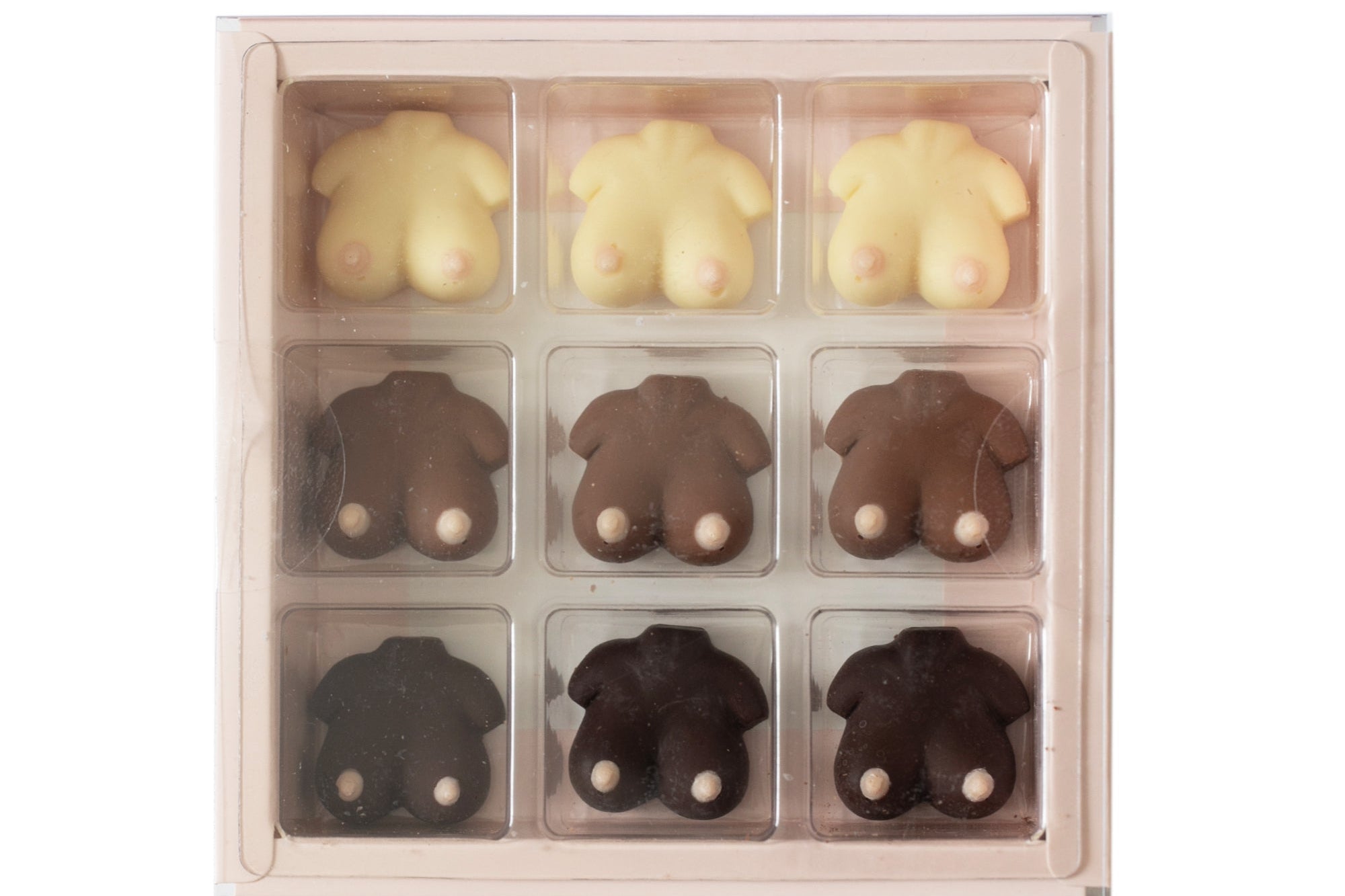 A 9-piece chocolate gift box featuring animal-shaped chocolates in three colors: pale cream, medium brown, and dark chocolate. The chocolates are shaped like sheep, cows, and pigs, with small white details on their faces.