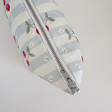 Nappy Wallet Cherry Stripe, top-down close-up of the closed silver zip running along the striped fabric