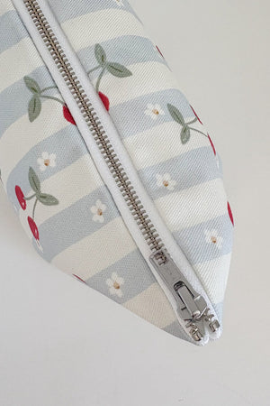 Nappy Wallet Cherry Stripe, top-down close-up of the closed silver zip running along the striped fabric